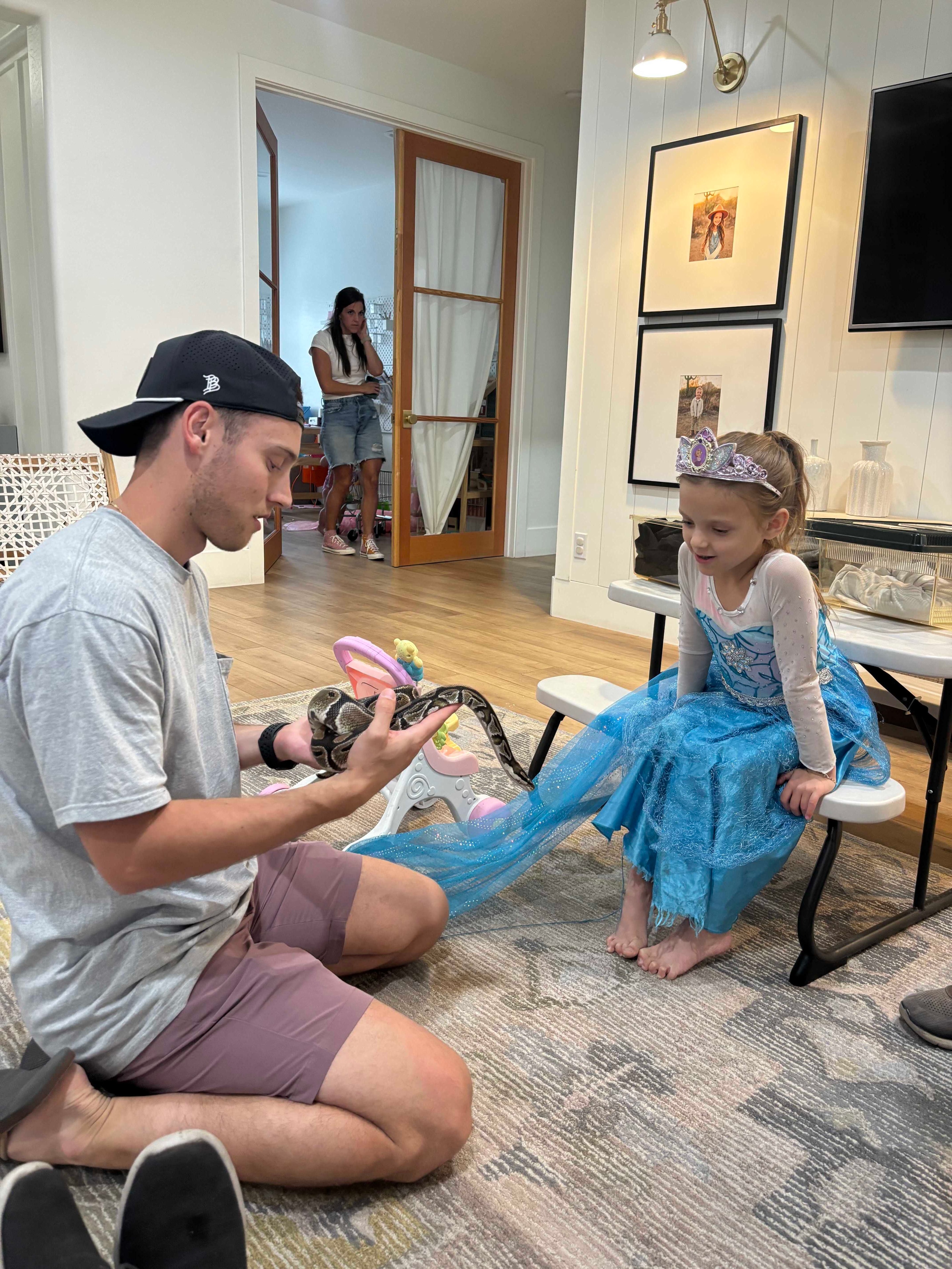 Presenter showing a snake to a child at a home event